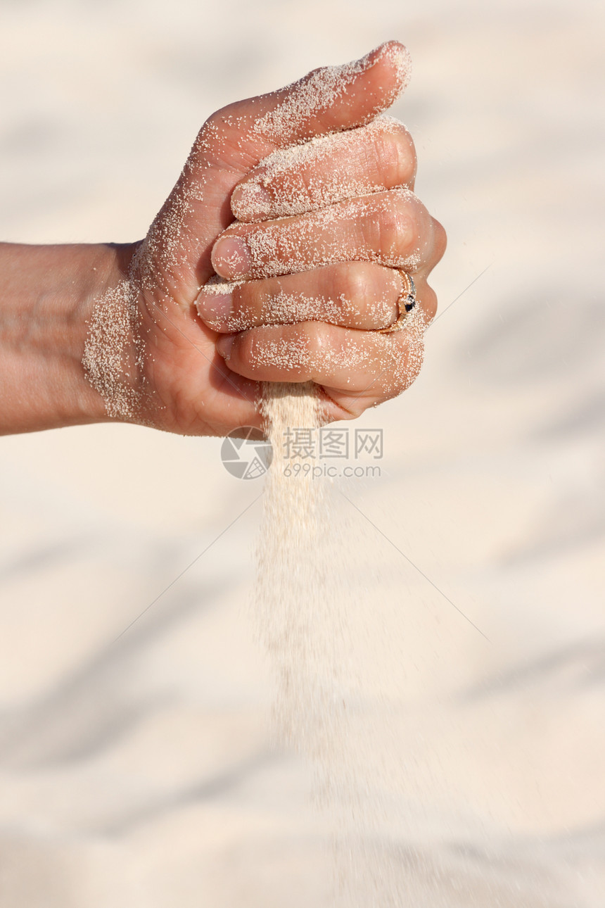 沙子亲手在沙沙中奔跑损失手指细流阳光悲伤破产沙漠海滩女士时间图片