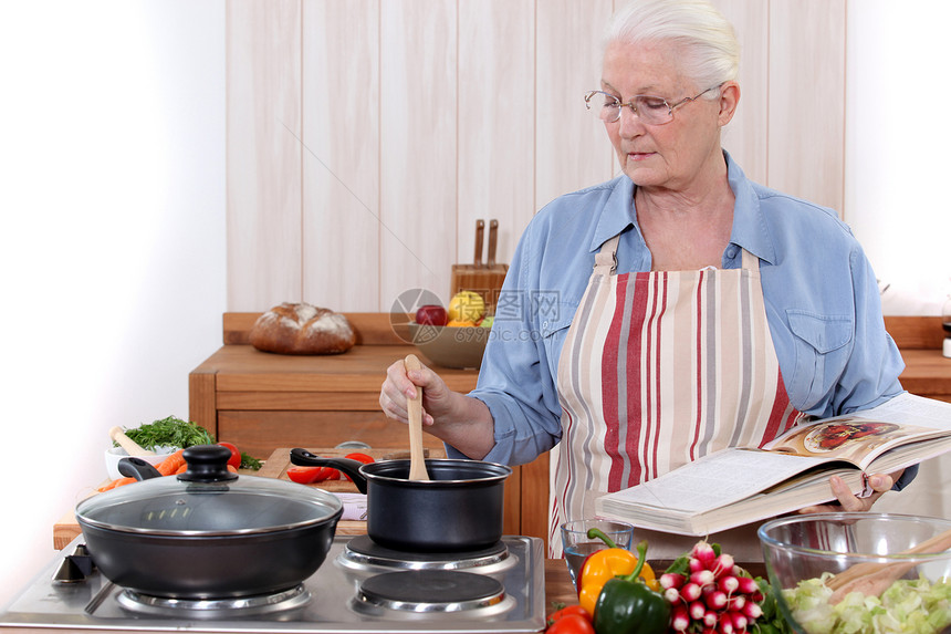 老年妇女做饭家具勺子白色胡椒平底锅食物蔬菜食谱生活围裙图片