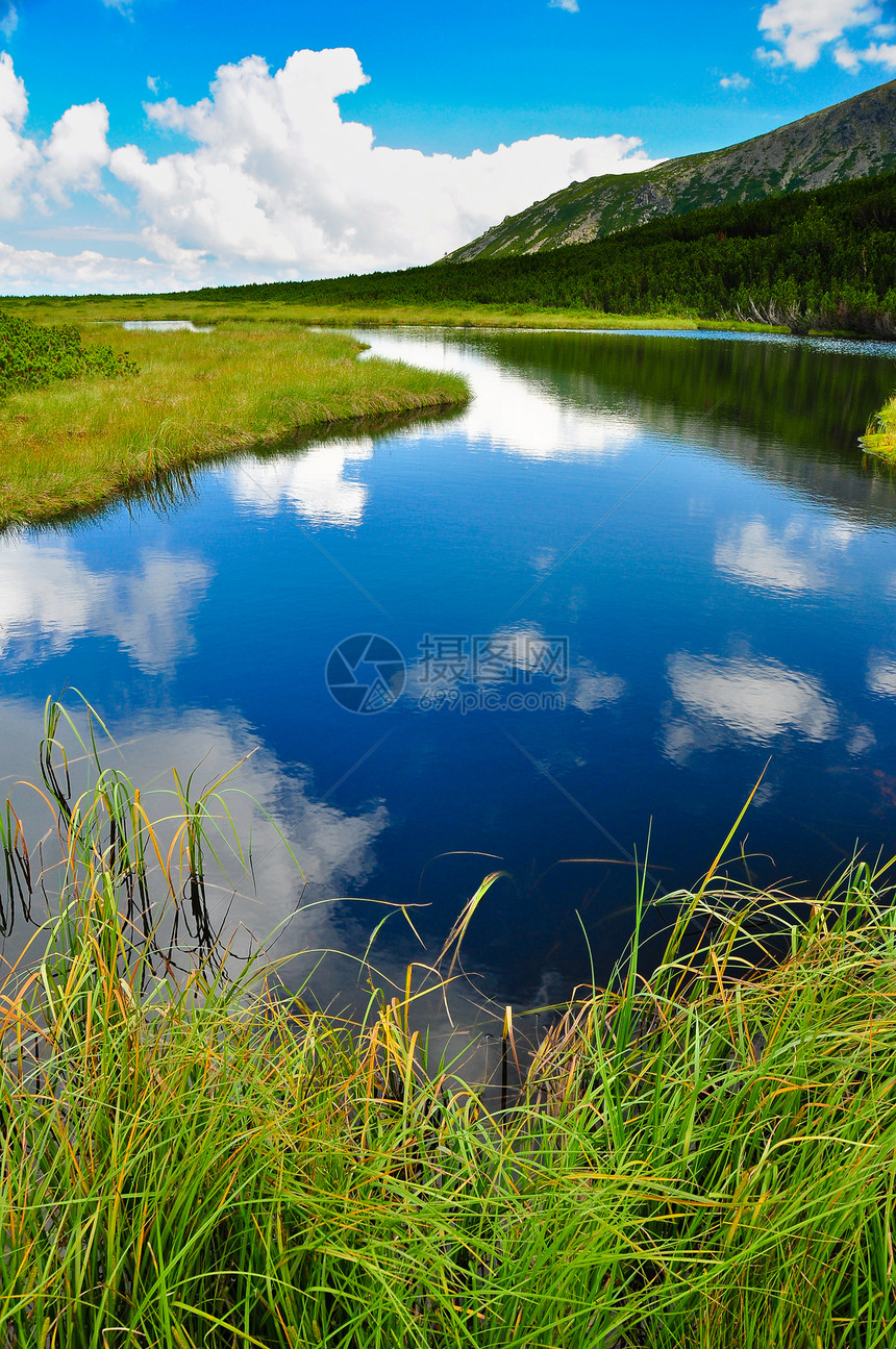 山湖天空和带草地前景的云反射图片