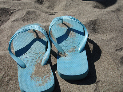 海滩上的蓝蓝色沙滩拖鞋背景图片