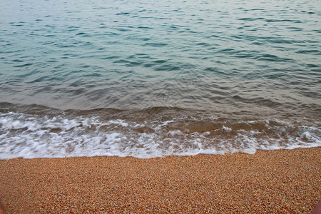 在沙沙滩上挥舞海浪泡沫断路器海滩天蓝色海岸蓝色浮渣银行背景图片