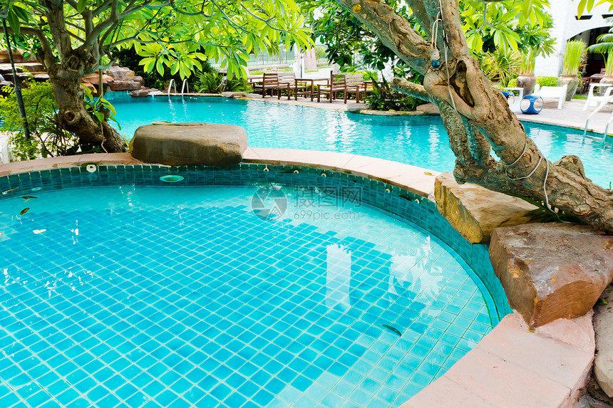 游泳池在度假村奢华旅游蓝色椅子棕榈花园桌子旅行休闲乐趣图片