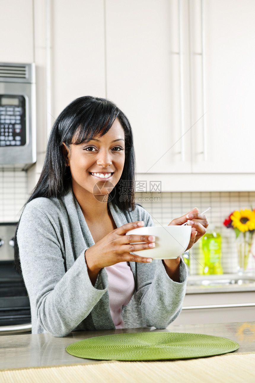 妇女吃早餐内饰房子勺子住宅女性厨房谷物家庭柜台台面图片