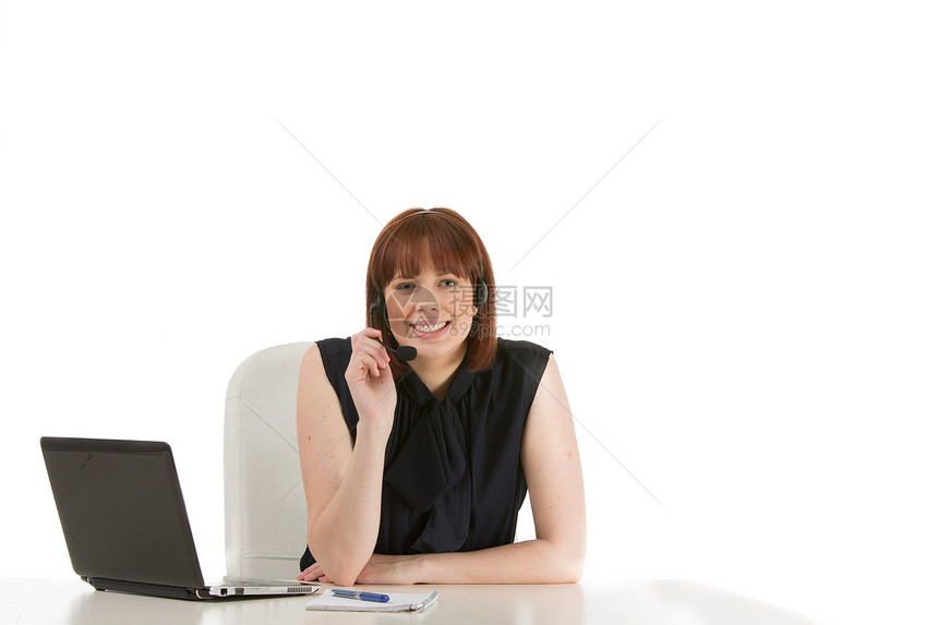 戴着耳头的笑容接待员办公室桌子笔记本工人电脑微笑中心操作员耳机女士图片