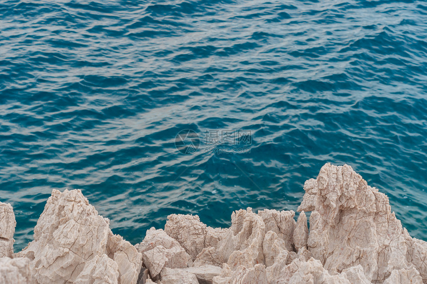 海岸的尖锐石块悬崖白色海洋岩石地质学编队荒野游客支撑剃刀图片