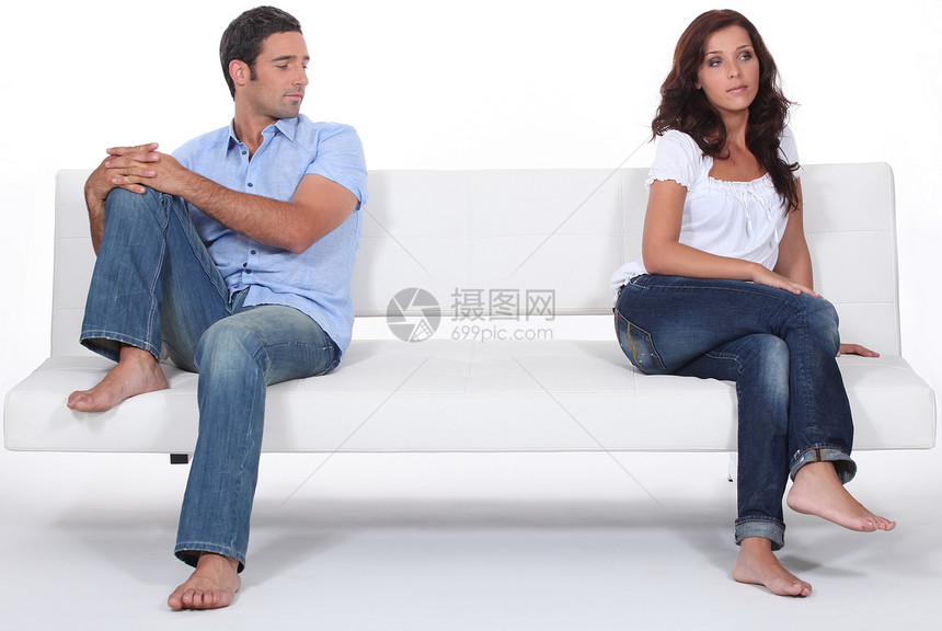 有不同意见的夫妻双方肩膀分歧白色牛仔裤斗争沙发男人争议女士妻子图片