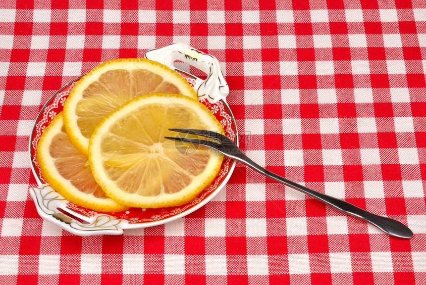 柠檬和叉子放在盘子上的柠檬图片