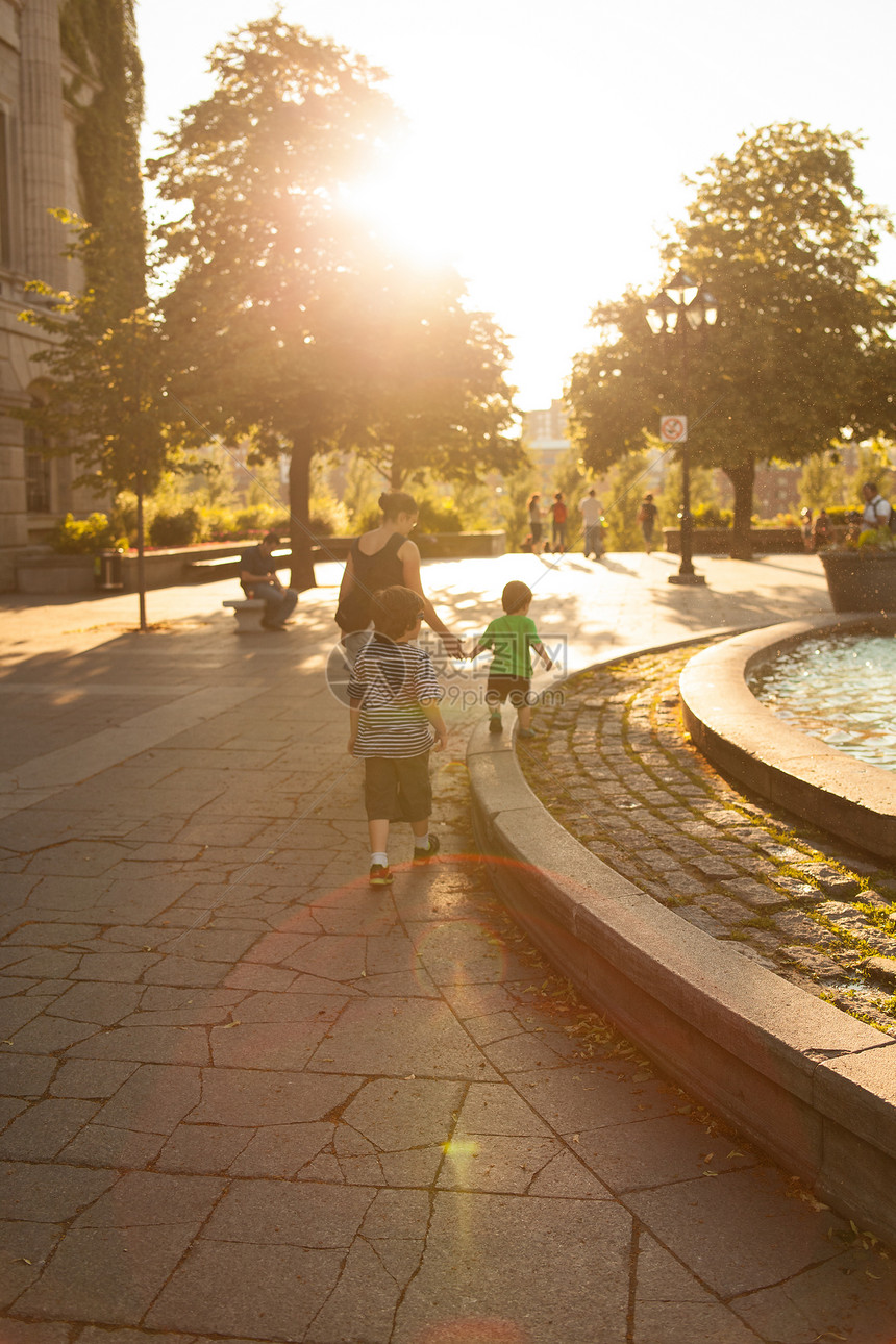 家庭步行喷泉女性兄弟女士城市成人儿子孩子日落母亲图片