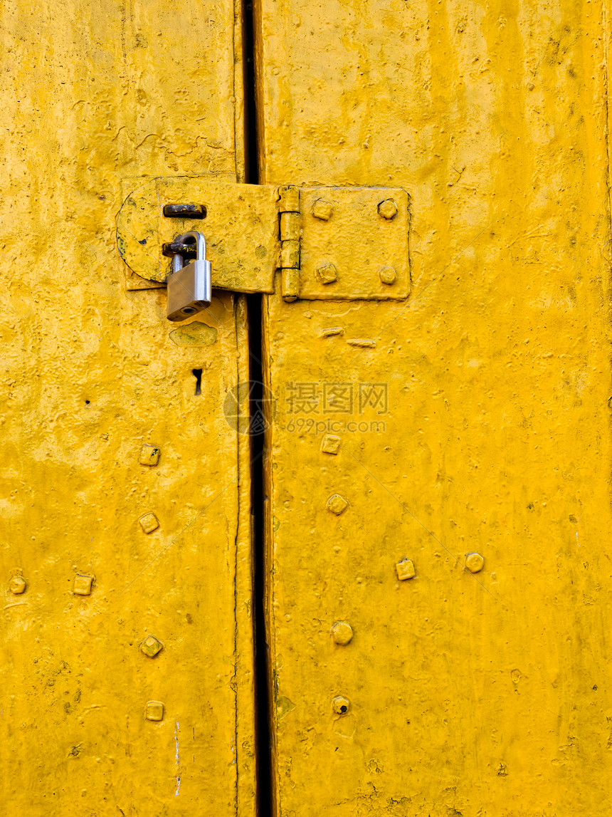 旧黄色门上的挂锁图片