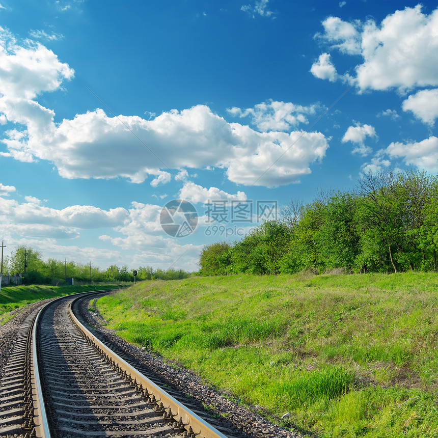 铁路在蓝色天空下直通绿色地平线 c图片