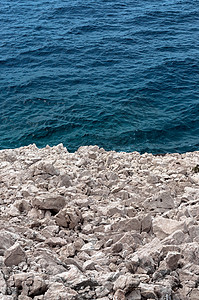 海岸的尖锐石块荒野石头蓝色编队岩石白色灰色支撑地质学游客背景图片