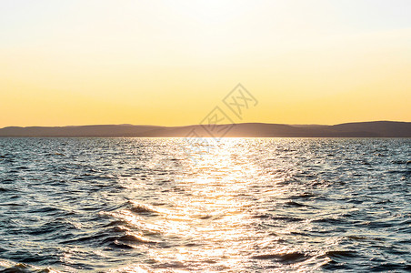 日落在海面太阳海洋天空地平线射线背景图片