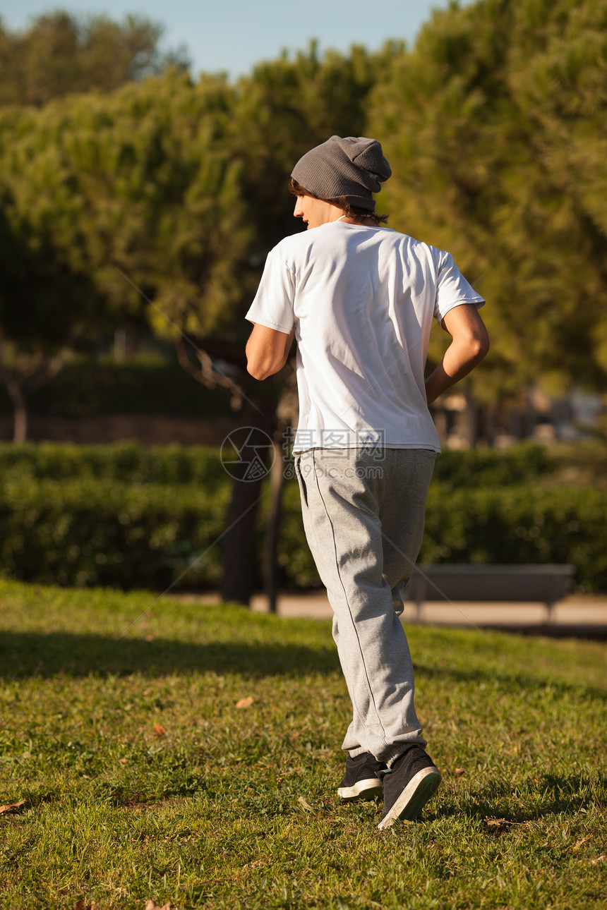 英俊的年轻人在公园里慢跑男性身体肌肉锻炼活力绿色男人乐趣娱乐白色图片