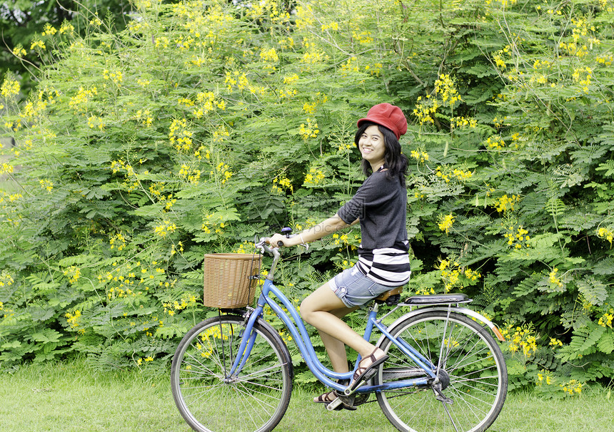 快乐笑笑的姑娘在公园骑自行车图片