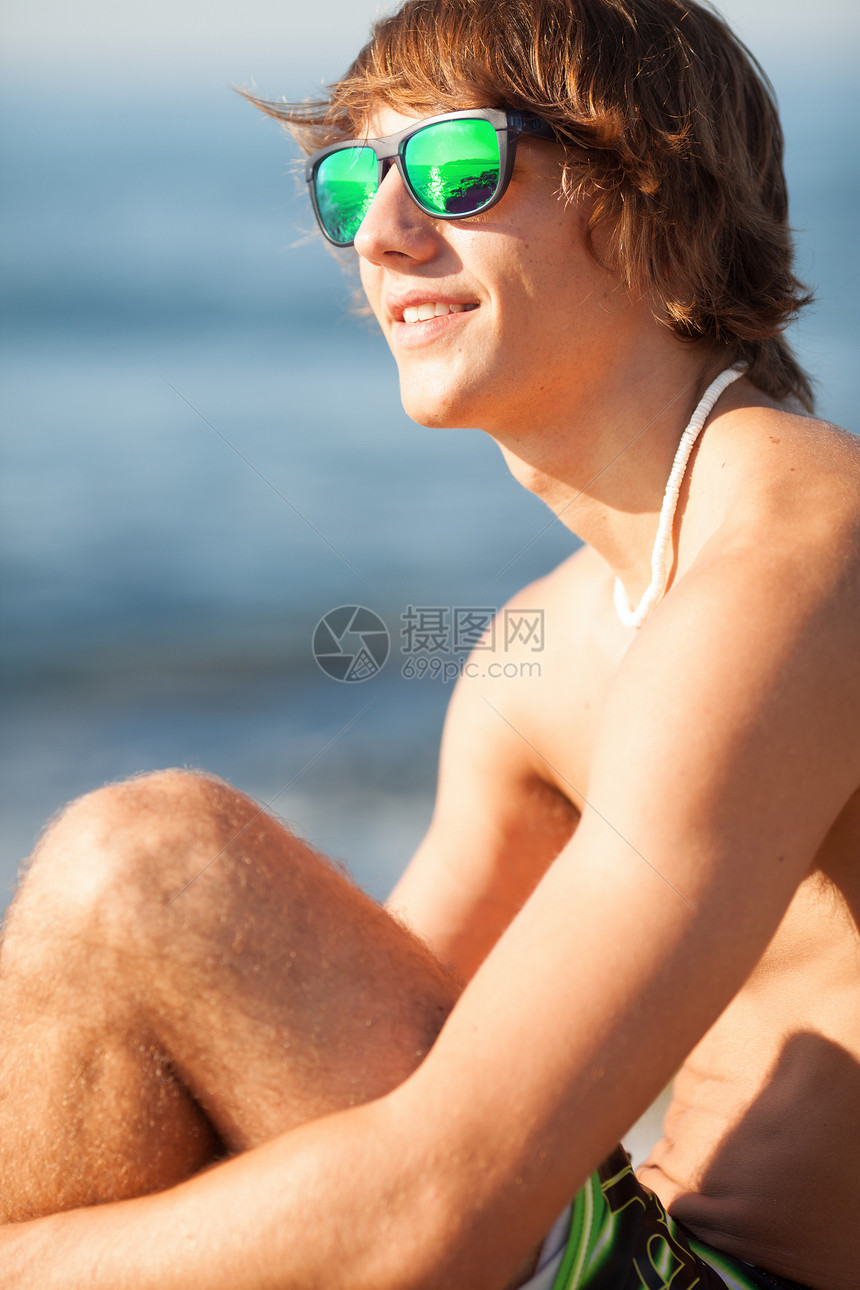年轻健康的美丽男人 在海滩上欢笑的肖像项链眼镜乐趣天空运动太阳蓝色绿色海洋享受图片