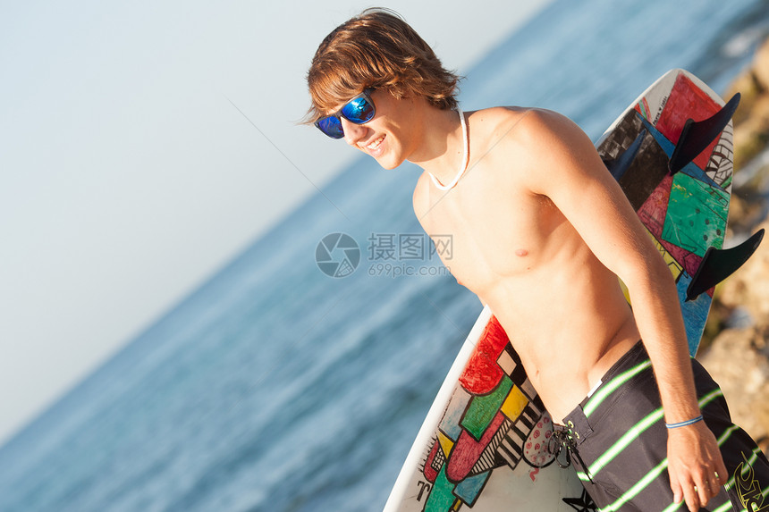 年轻冲浪者即将进海海洋眼镜运动桌子乐趣太阳男人波浪海滩项链图片