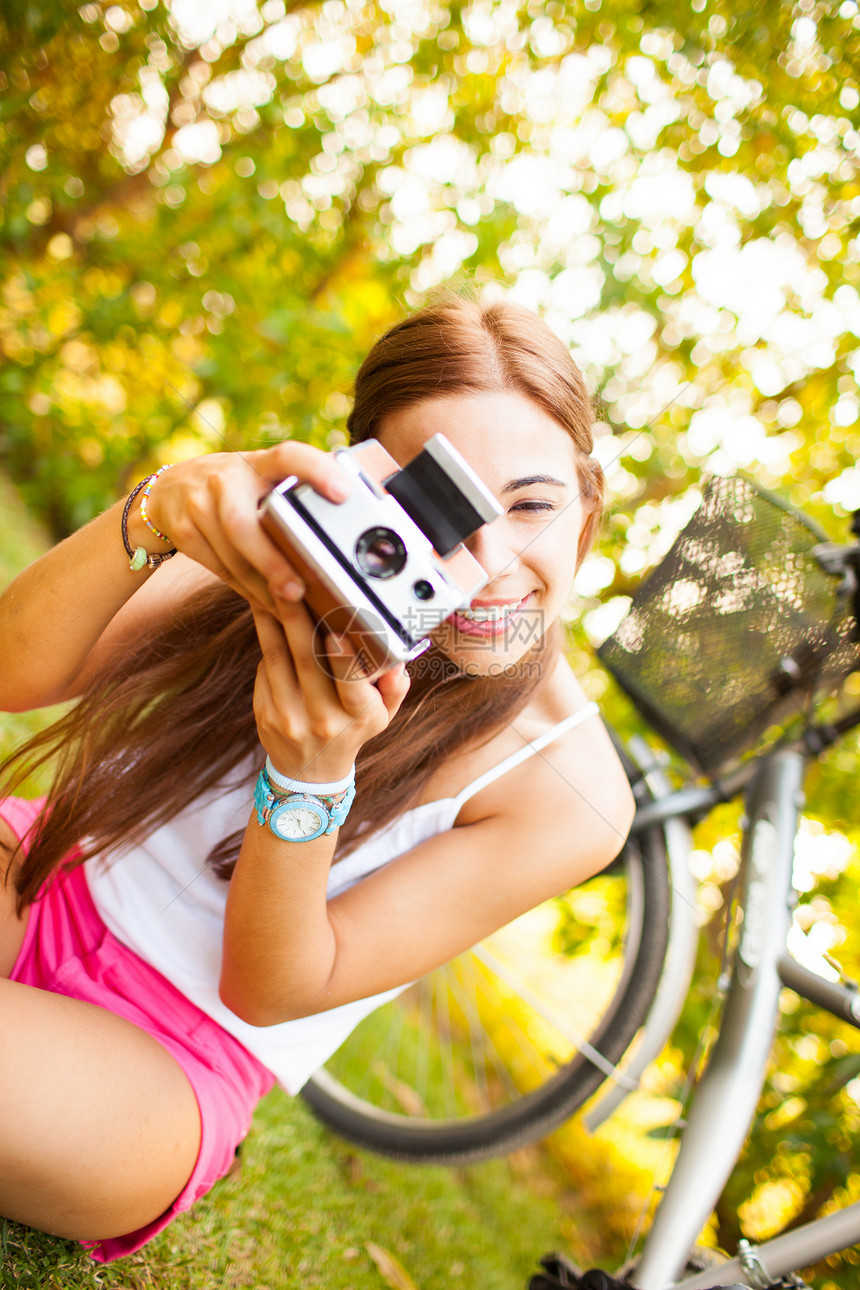 美丽的年轻女子玩着古老的相机自由绿色女孩场地手表旅行眼镜照片女性黄色图片