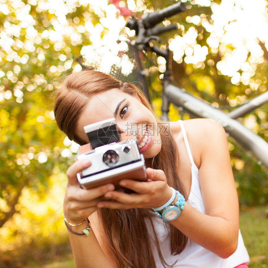 美丽的年轻女子玩着古老的相机旅行黄色绿色眼镜女性女孩照片手表自由场地图片