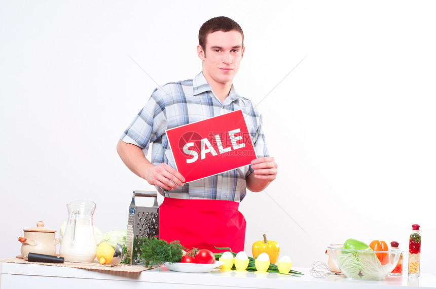 一位年轻男子的肖像 持有销售标记桌子胡椒黄瓜营养乐趣幸福食物快乐饮食早餐图片