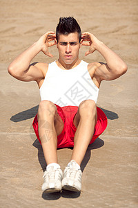 英俊的年轻人做腹肌锻炼救生员腹部健康肌肉男人太阳背景图片