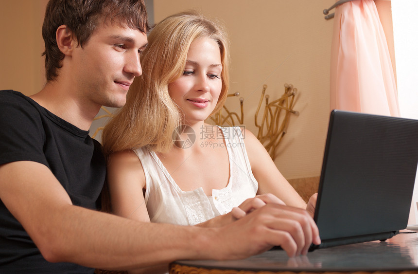 带膝上型电脑的年轻夫妇桌子咖啡杯子学生女性友谊夫妻女孩微笑女朋友图片