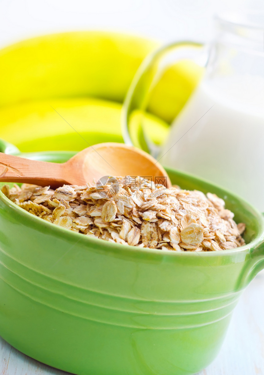 绿碗中含香蕉和牛奶的煤炭片片木头玉米片早餐营养酸奶篮子薄片木板低脂肪水果图片