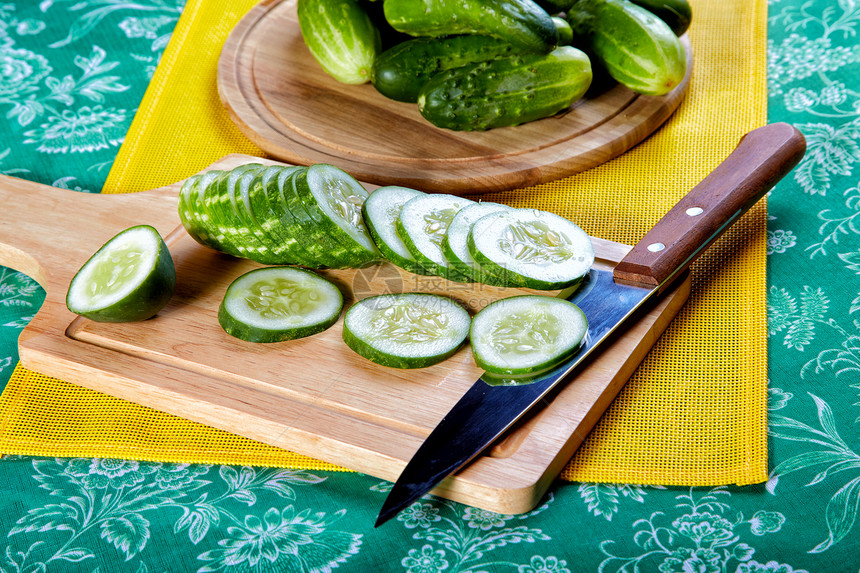 在厨房桌上切开的绿黄瓜和刀子营养品蔬菜营养绿色美食桌子静物图片