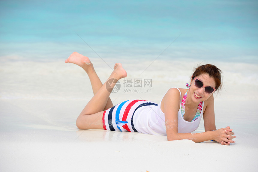 躺在沙滩上微笑的美女躺在沙滩上图片