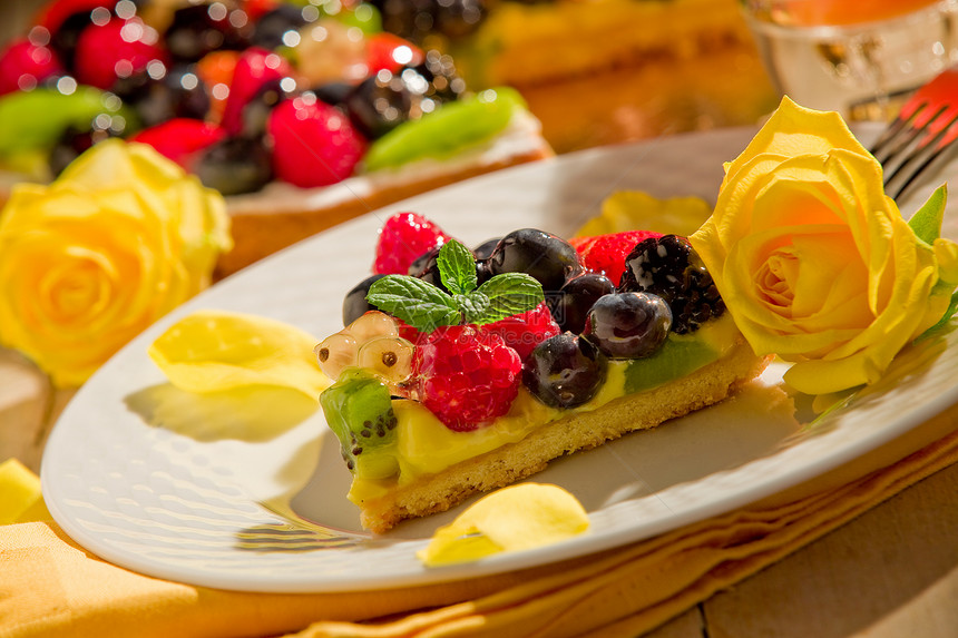 用蜡烛照亮的水果和花瓣桌木餐巾纸蛋糕甜点食物薄荷糕点浆果玫瑰奇异果图片