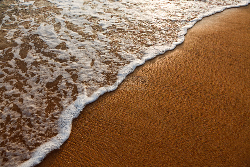 波浪在沙滩上涌起热带假期泡沫海洋海岸日落海浪图片