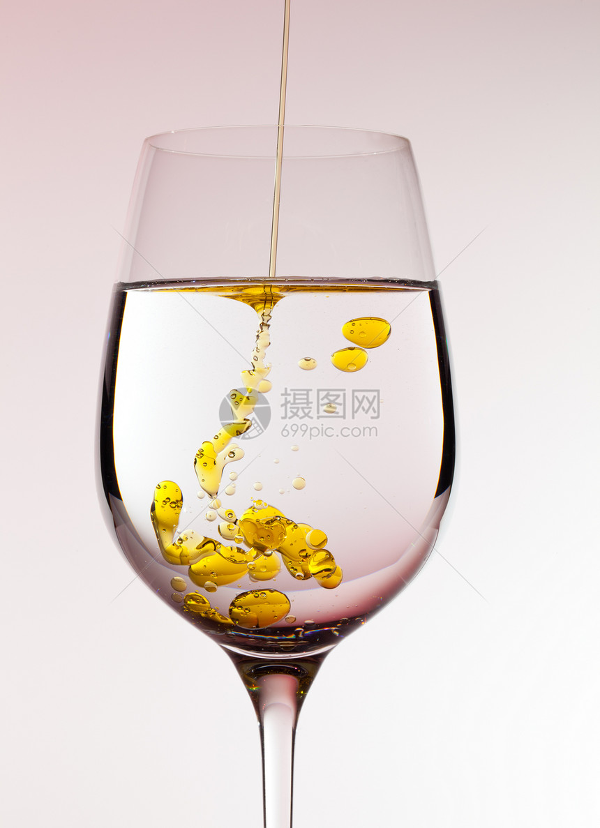 橄榄油被倒入葡萄酒杯溪流玻璃飞溅水滴酒杯向日葵液体黄色流动金子图片
