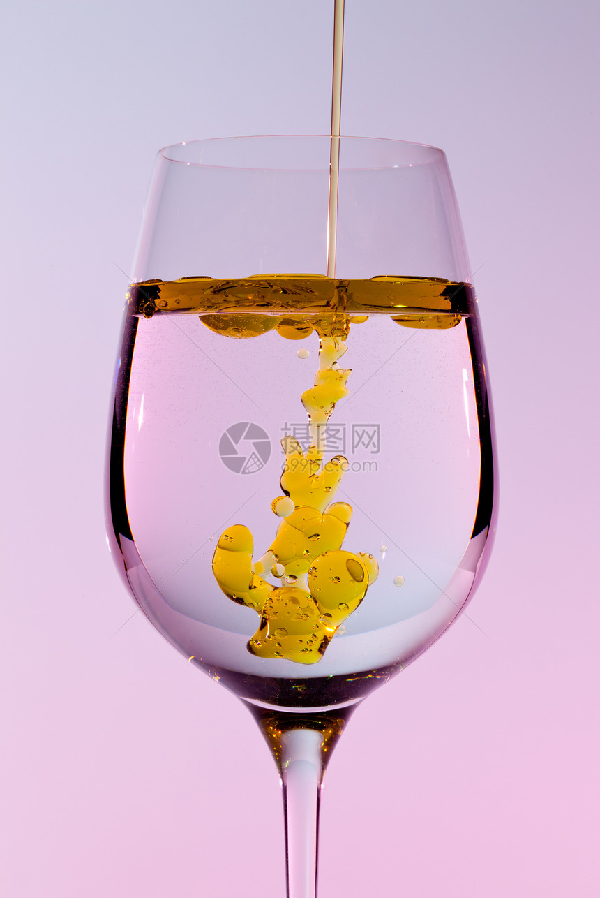 橄榄油被倒入葡萄酒杯玻璃高脚杯液体酒杯金子宏观飞溅向日葵流动黄色图片