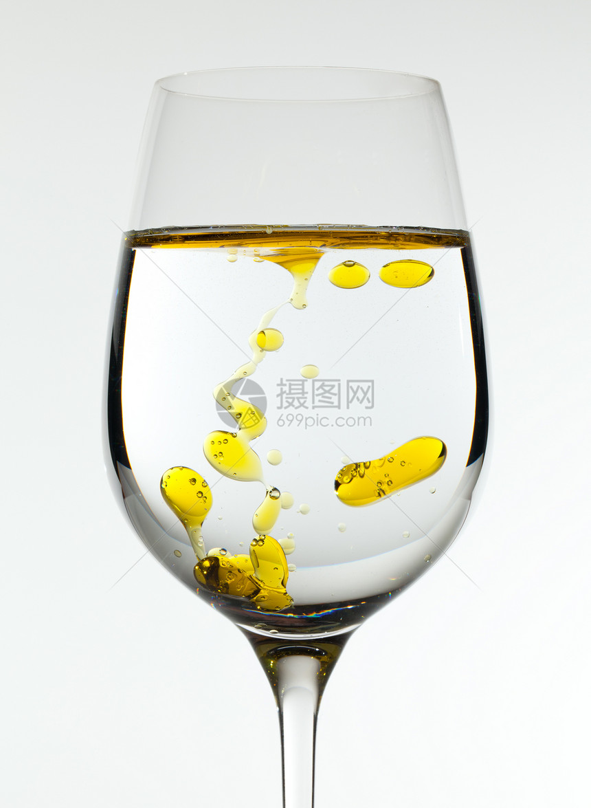 橄榄油被倒入葡萄酒杯运动向日葵飞溅高脚杯酒杯水滴流动金子透明度黄色图片
