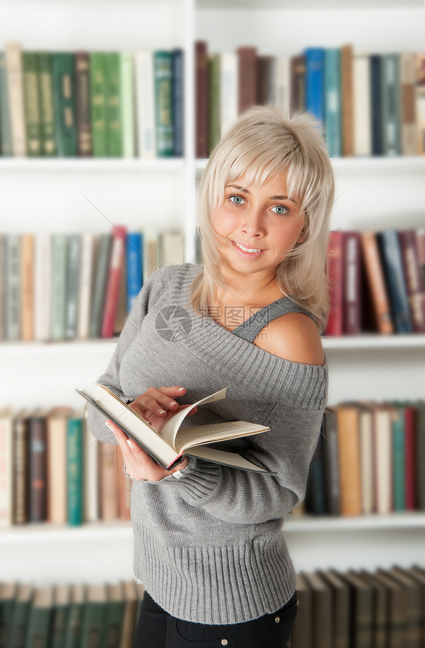 金发金发 拿着一本书架学生学校书店文学大学女性青少年教育学习教科书图片