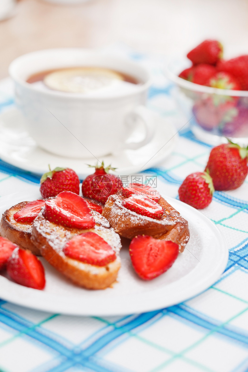 配有糖粉和草莓的法式吐司食物烹饪柠檬杯子红色早餐美食油炸肉桂糖浆图片