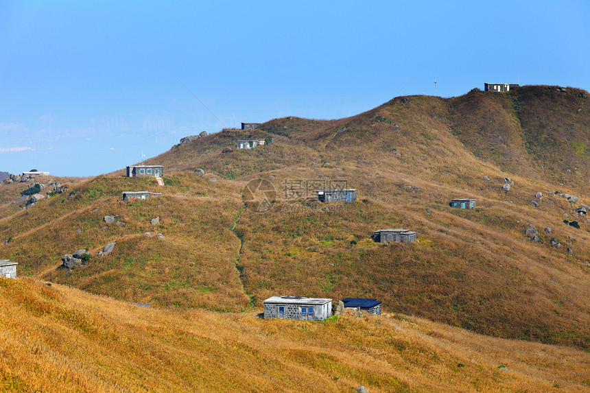 山上的房子蓝色环境财产爬坡草地天空土地绿色建筑投资图片