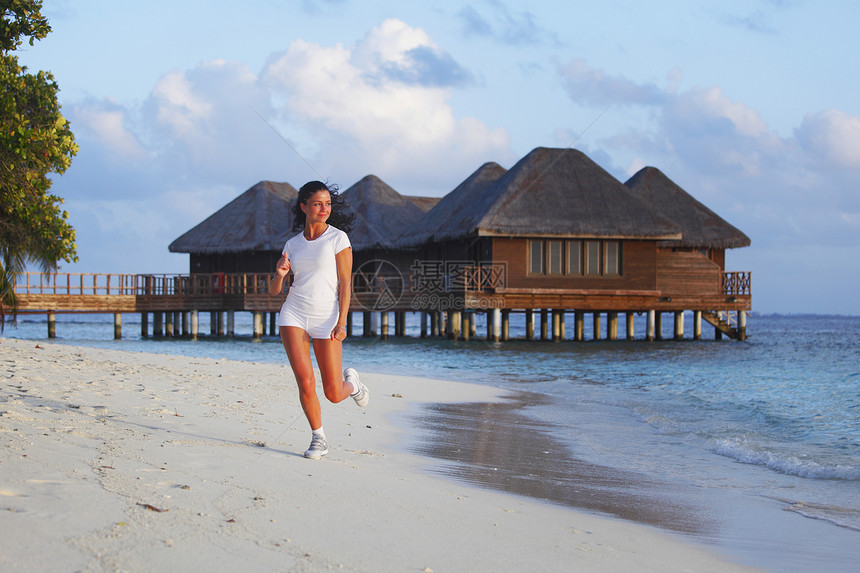 女人在海滩上奔跑日落女性运动员酒店热带海洋训练慢跑者别墅女孩图片