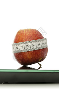 以比例尺测量磁带包裹的苹果背景图片