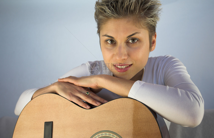 女人和吉他手金发吸引力音乐家情感声学头发插头仪器女孩吉他图片