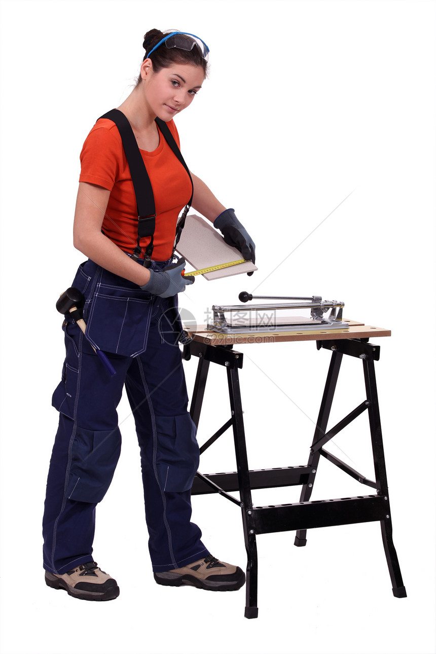 女人用瓷砖切刀杂工作坊统治者女士工人材料地面白色女性测量图片