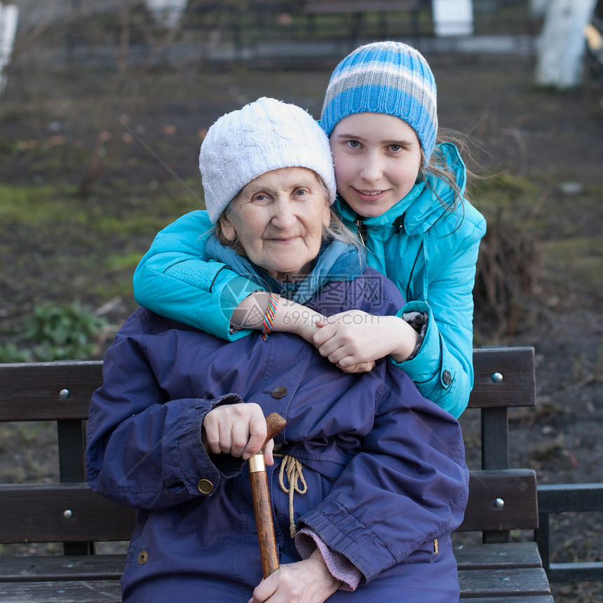孙女抱着她的外祖母温暖肩膀老人女性拥抱家庭父母快乐亲热灰色图片