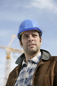 建筑工料工地顾问男性专家领班工程师头盔承包商设计师安全帽蓝图背景
