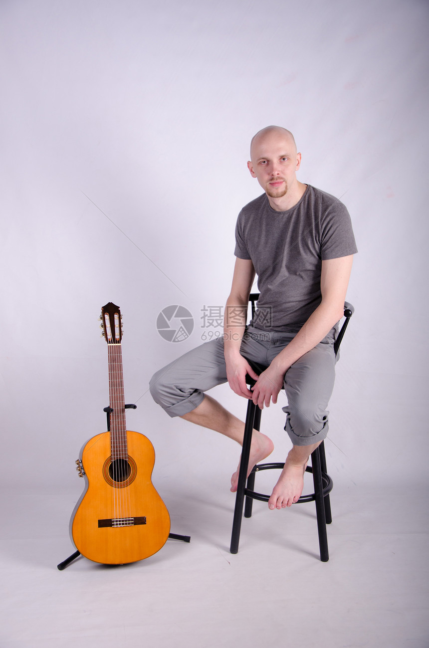 拿着吉他光秃秃的好人乐趣摇杆流行音乐头发吉他手音乐家男性娱乐牛仔裤岩石图片