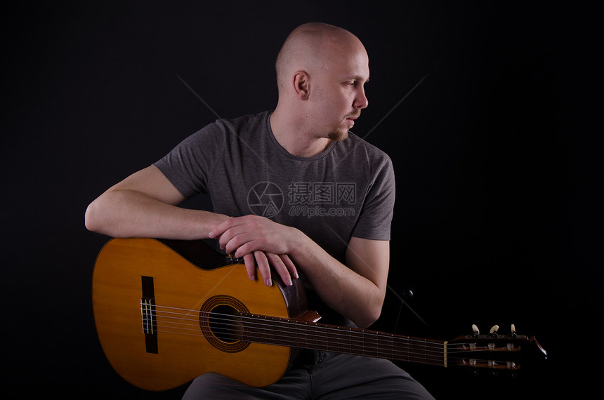 拿着吉他光秃秃的好人音乐家男性岩石帽子娱乐摇杆头发生活流行音乐男人图片