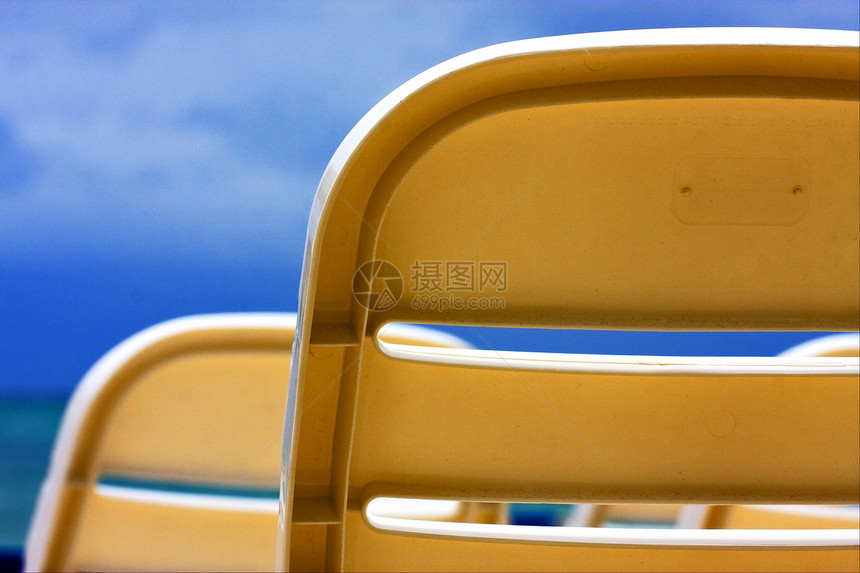 天空中的两张旧塑料椅子座位灌木丛旅行假期阴影海洋黄色白色图片