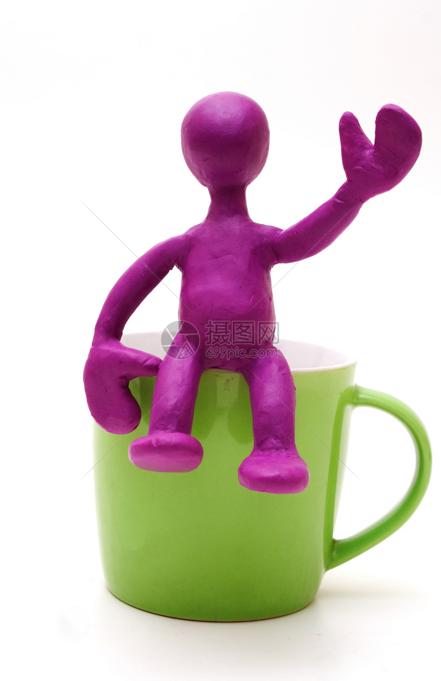 杯子上坐着可塑胶的紫色木偶图片