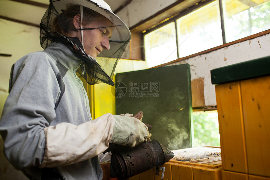 养蜂员在甲板上工作 持有一个蜂窝架手套工人生产蜂窝面纱快乐昆虫养蜂业养蜂人农场图片