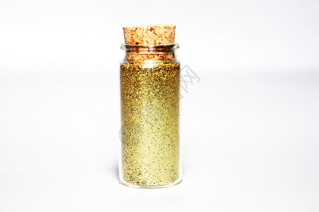 玻璃小瓶中金色闪光粉背景图片