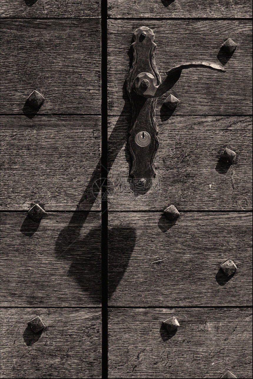 贝林佐纳的木门切口气泡灰色反射棕色指甲黑色快门木头黄铜图片