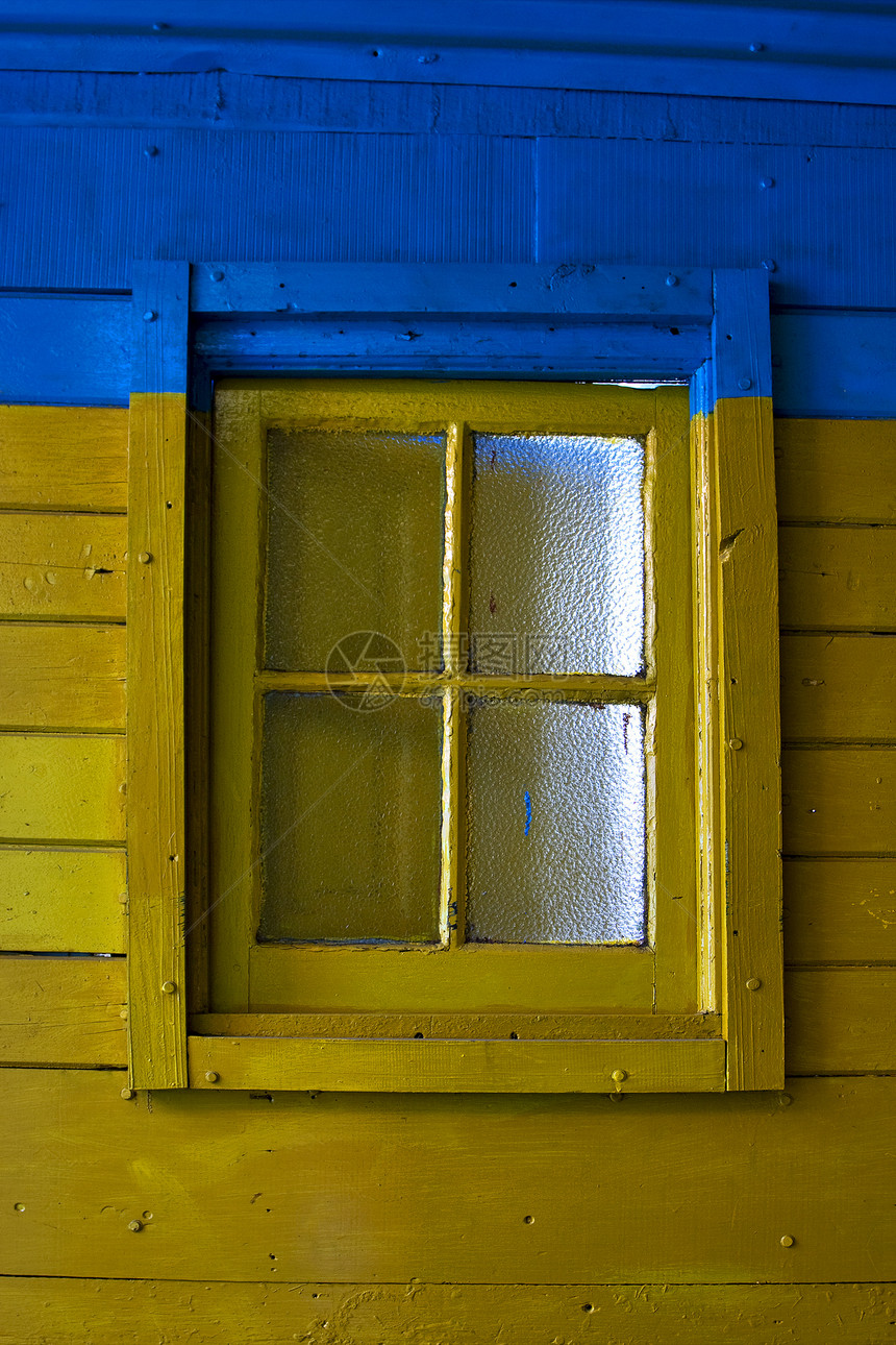 蓝色墙上的旧黄色窗口历史锁定房子木头气泡指甲灌木丛窗户玻璃浅蓝色图片